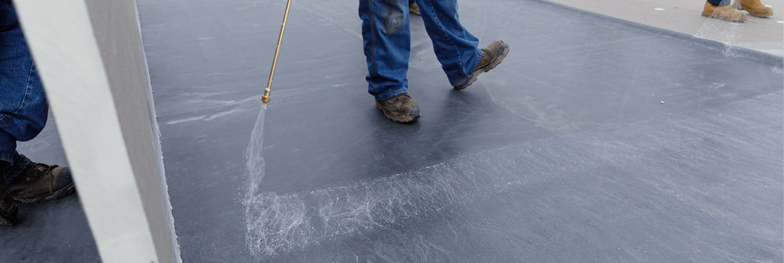 Contractor spraying Jet Bond adhesive on polyiso insulation